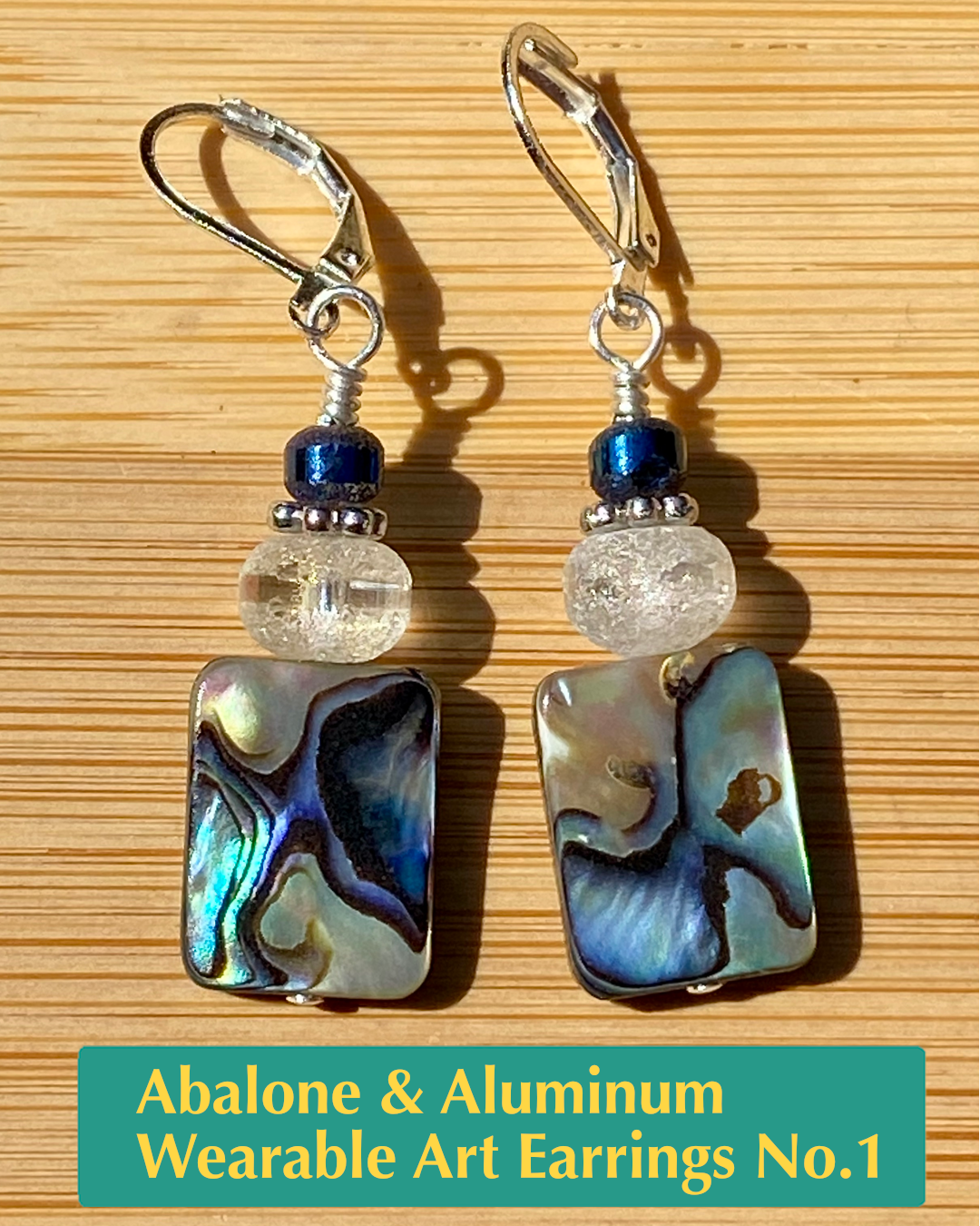 handmade lever back earrings with metal, metallic striped crystal, and abalone shell beads and silver plated brass metals.