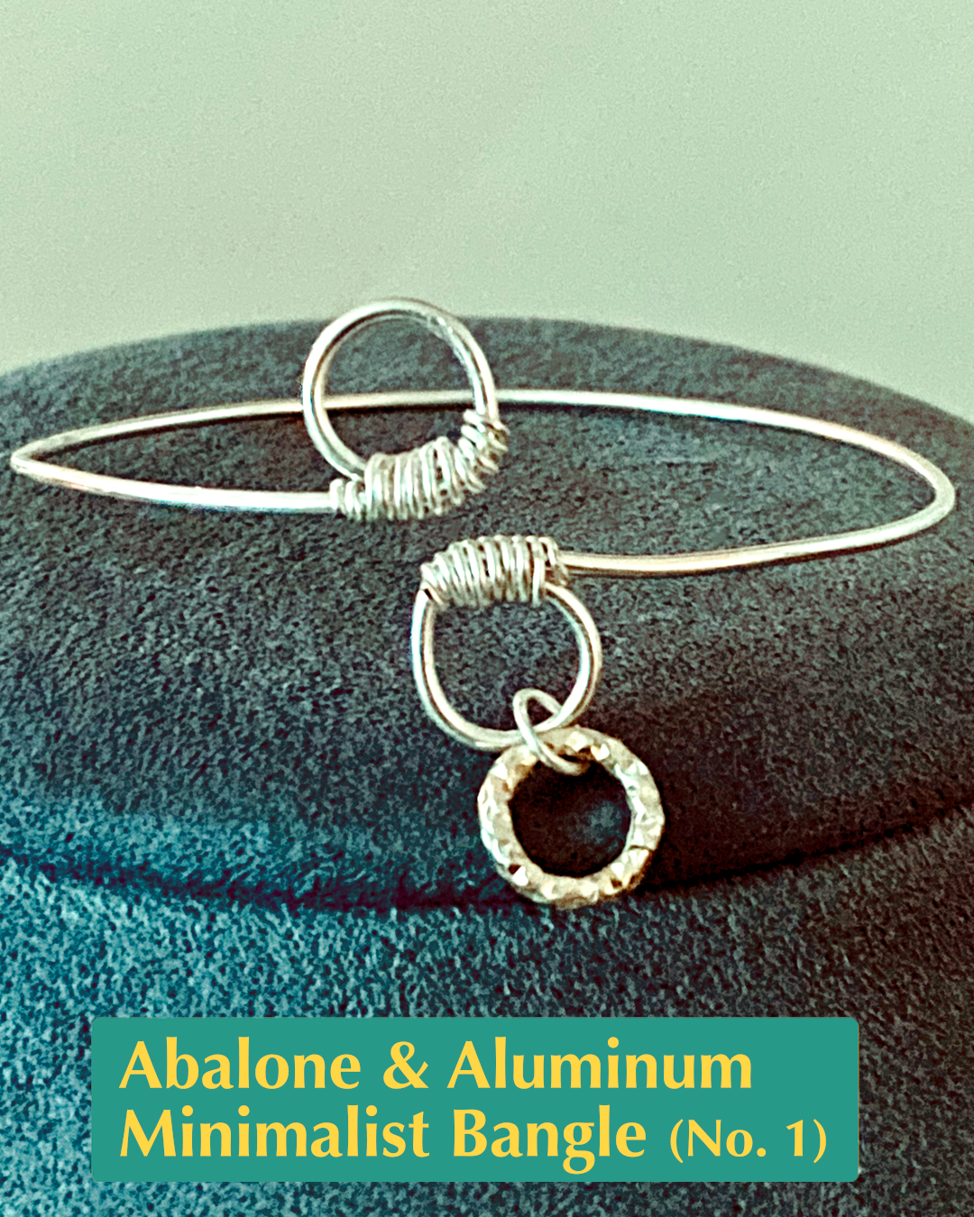 handmade silver-filled open bangle with wire wrapped circle loop ends accented with a textured circle aluminum charm