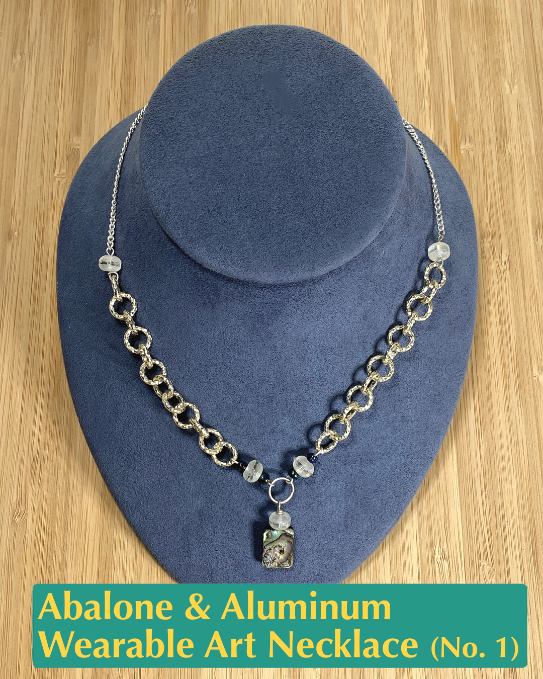 handmade necklace with textured aluminum and silver-plated chain, crystal and salvaged bead accents, and an abalone charm