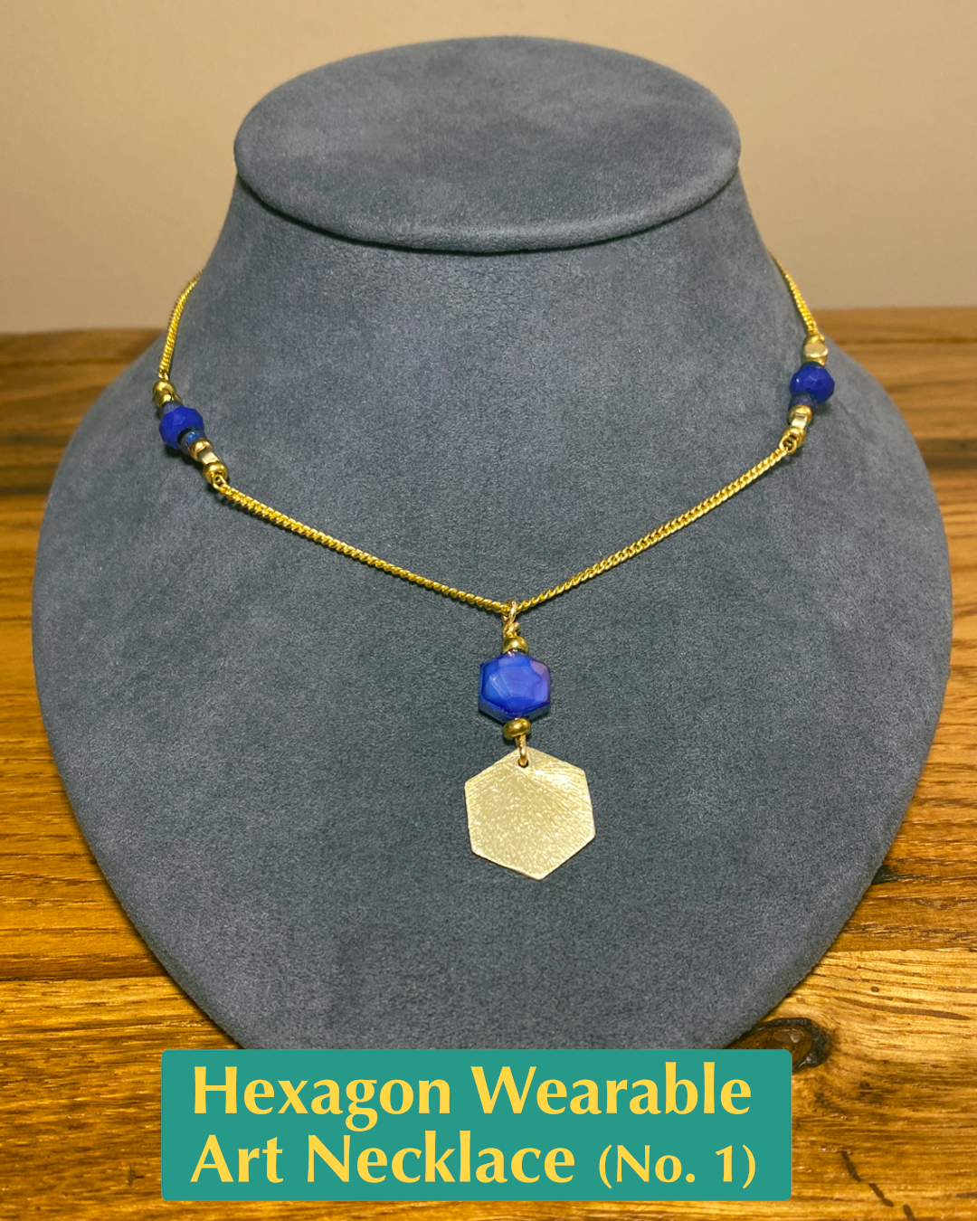 Handmade necklace with blue and gold bead accents and a blue crystal and gold-plated hexagon pendant