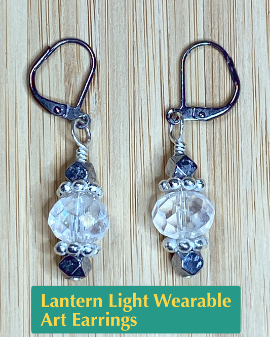 Handmade earrings made of hematite, glass, and metal beads that are shaped like lanterns