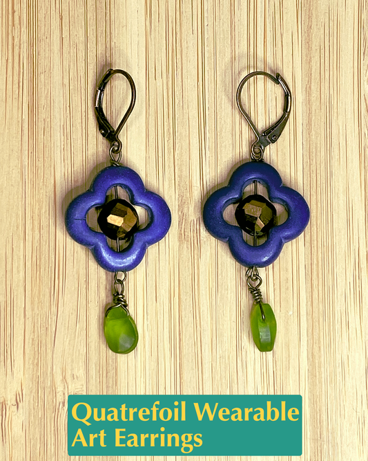 Handmade, wearable art lever back earrings with blue and gold quatrefoil flower accent with a green petal dangle