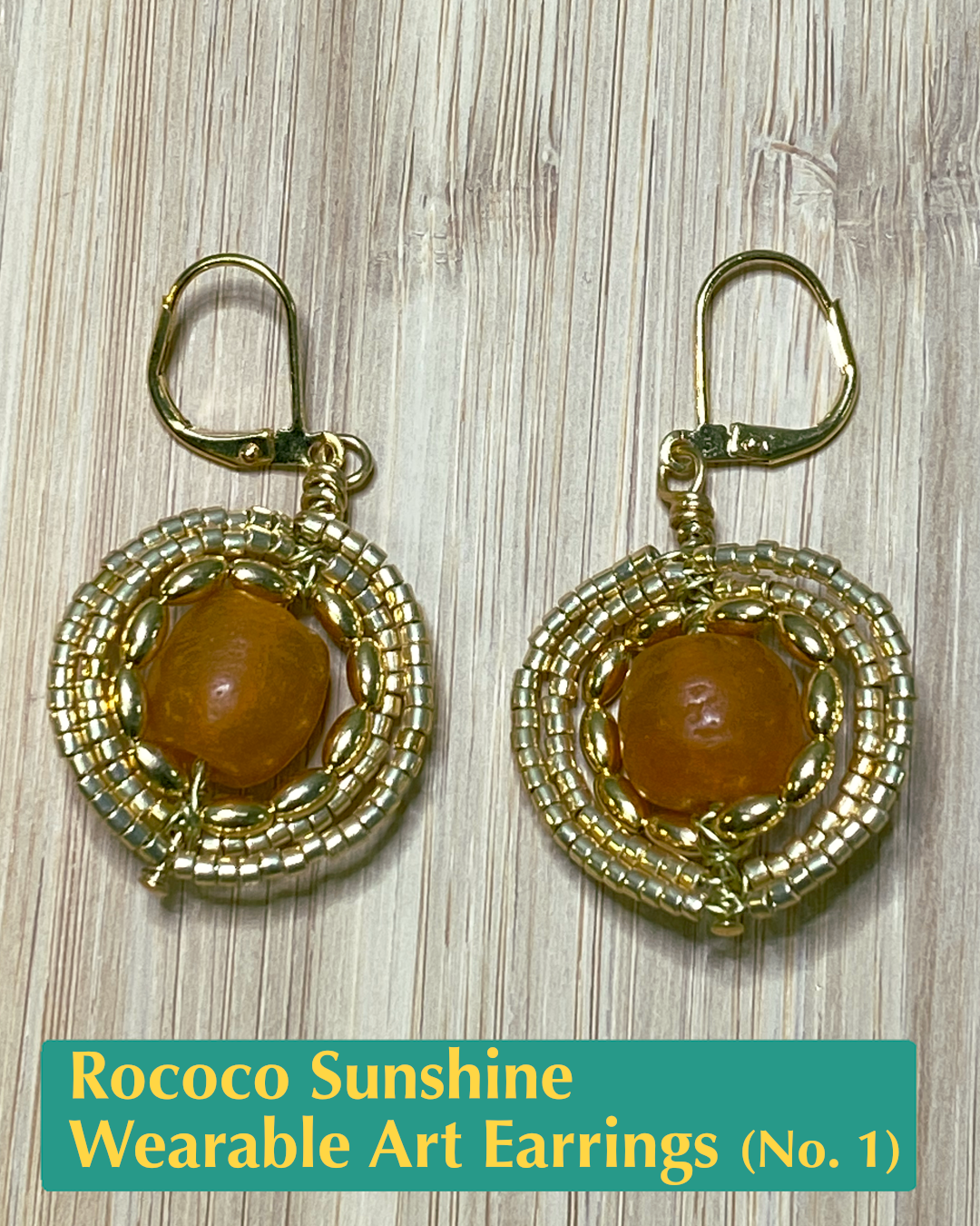 Handmade, wearable art earrings made from gold-colored metals featuring a large orange bead encircled by small gold beads