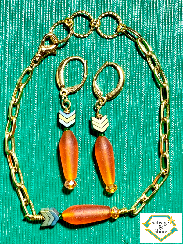 wearable art earrings and bracelet set with gold metals and with beaded carrot charms  (an orange root and green stem and leaves).  The bracelet is a paperclip chain.