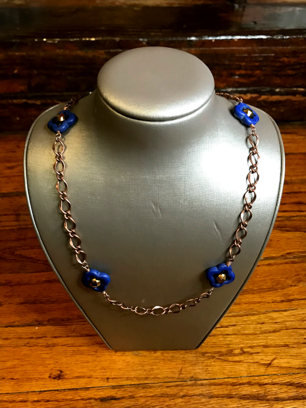 Handmade, wearable art quatrefoil necklace on display